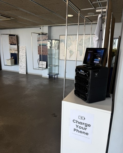 Estación Voltify instalada en un showroom, sobre un pedestal junto a la entrada